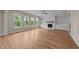Spacious living room with a white brick fireplace, wood mantle, built-in shelving, and hardwood floors at 90 Lane Farms Way Way, Holly Springs, NC 27540
