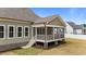 Close-up of the rear screened porch showing its access stairs, wood-tone rails, and brick support columns at 90 Lane Farms Way Way, Holly Springs, NC 27540