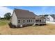 Rear exterior featuring a screened porch, meticulous landscaping, neutral siding, and large windows at 90 Lane Farms Way Way, Holly Springs, NC 27540
