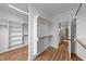 A walk-in closet with built-in shelving and wood flooring and a doorway to bathroom at 90 Lane Farms Way Way, Holly Springs, NC 27540