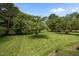 Expansive backyard with lush green grass and mature trees, offering a serene outdoor space at 913 Milton Rd, Durham, NC 27712