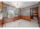 Bright dining area with wood paneling, a window with backyard view, and a decorative chandelier at 913 Milton Rd, Durham, NC 27712