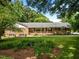 Charming brick home featuring a lush green lawn, well-maintained landscaping, and inviting front porch at 913 Milton Rd, Durham, NC 27712
