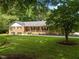Beautiful brick home with a covered front porch, nestled within a lush green lawn and mature trees at 913 Milton Rd, Durham, NC 27712