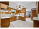 Traditional kitchen with wood cabinets, white appliances, and tile flooring, offering a functional cooking space at 913 Milton Rd, Durham, NC 27712