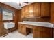 Laundry room featuring wood paneled walls and cabinets, white countertops and sink at 913 Milton Rd, Durham, NC 27712