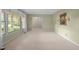 Bright, carpeted living room featuring large windows with views of the outdoors, sconces, and neutral walls at 913 Milton Rd, Durham, NC 27712