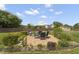 This is a backyard featuring a stone patio with a wrought iron fence, furniture, and professional landscaping at 1001 Pasture View Ln, Raleigh, NC 27603