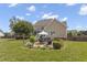 This backyard has a stone patio with chairs, an umbrella, a well manicured lawn, and mature trees at 1001 Pasture View Ln, Raleigh, NC 27603