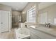Bright bathroom featuring a soaking tub, separate shower, and dual vanities with plentiful light at 1001 Pasture View Ln, Raleigh, NC 27603