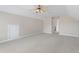 The bonus room features a ceiling fan, neutral paint and carpet, and a doorway leading to another room at 1001 Pasture View Ln, Raleigh, NC 27603