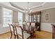 Elegant dining room with a chandelier, hardwood floors, and ample natural light from large windows at 1001 Pasture View Ln, Raleigh, NC 27603
