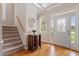 Bright foyer with hardwood floors, staircase, and natural light streaming through the decorative front door at 1001 Pasture View Ln, Raleigh, NC 27603