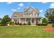 Inviting two-story home featuring a charming front porch, manicured lawn, and beautiful landscaping at 1001 Pasture View Ln, Raleigh, NC 27603