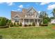 Attractive two-story home with a charming front porch, lush lawn, and professionally designed landscaping at 1001 Pasture View Ln, Raleigh, NC 27603