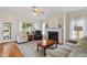 Cozy living room with a fireplace, plush seating, and large windows providing ample natural light at 1001 Pasture View Ln, Raleigh, NC 27603
