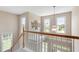 Bright stairwell features a decorative tree, pendant lighting, and three windows overlooking a well-manicured lawn at 1001 Pasture View Ln, Raleigh, NC 27603