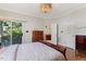 Comfortable bedroom with balcony access, ensuite bath, and chandelier lighting at 101 Cardiff Pl, Chapel Hill, NC 27516