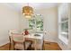 This dining room has a stylish chandelier, window with blinds and wood floors at 101 Cardiff Pl, Chapel Hill, NC 27516