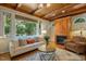 Inviting living room features wood-beamed ceilings, fireplace, and large windows with a lush view at 101 Cardiff Pl, Chapel Hill, NC 27516