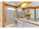 Modern bathroom featuring double sinks with granite countertops, a walk-in shower, and elegant tile work at 1019 Tranquil Crk Way, Wake Forest, NC 27587