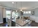 Bright kitchen featuring an island with granite countertops, stainless steel appliances, and an open dining area at 1019 Tranquil Crk Way, Wake Forest, NC 27587