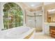 Primary bathroom features a soaking tub, glass shower and large window at 104 San Sophia Dr, Chapel Hill, NC 27514