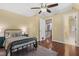Cozy bedroom with hardwood floors, a ceiling fan, and an open door to a hallway at 104 San Sophia Dr, Chapel Hill, NC 27514