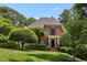 Beautiful brick home featuring lush landscaping, manicured lawn and mature trees at 104 San Sophia Dr, Chapel Hill, NC 27514