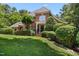 Well-manicured lawn and landscaping accentuate this brick two-story home with black front door at 104 San Sophia Dr, Chapel Hill, NC 27514