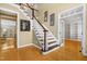 Spacious foyer featuring hardwood floors and staircase with white spindles and stained wood railing at 104 San Sophia Dr, Chapel Hill, NC 27514