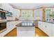 Bright eat-in kitchen features white cabinets, stainless steel appliances and a center island with granite counters at 104 San Sophia Dr, Chapel Hill, NC 27514