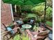 Inviting stone patio with adirondack seating around a small green table in a landscaped backyard at 104 San Sophia Dr, Chapel Hill, NC 27514