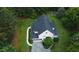 An aerial view showcasing a home, garage, driveway, and lush landscaping with mature trees at 1123 Poplar Forest Ln, Pittsboro, NC 27312