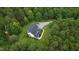 An aerial view of a house nestled in a lush, green, wooded area with a long driveway at 1123 Poplar Forest Ln, Pittsboro, NC 27312