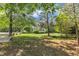 Private backyard featuring mature trees, lush grass, a hammock, and outdoor seating at 1123 Poplar Forest Ln, Pittsboro, NC 27312
