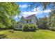 Expansive backyard view showcasing lush landscaping, a screen porch and mature trees at 1123 Poplar Forest Ln, Pittsboro, NC 27312