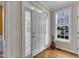 Bright foyer featuring hardwood floors, a white front door with sidelights, and a window for natural light at 1123 Poplar Forest Ln, Pittsboro, NC 27312
