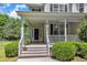 Inviting front porch entrance with decorative hanging plants and freshly painted white railings and brown stairs at 1123 Poplar Forest Ln, Pittsboro, NC 27312