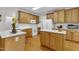 Spacious kitchen with wooden cabinets, white appliances, and countertops with stainless steel sink at 1123 Poplar Forest Ln, Pittsboro, NC 27312