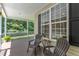 Relaxing covered porch featuring neutral-colored chairs, a side table, and views of the surrounding nature at 1123 Poplar Forest Ln, Pittsboro, NC 27312