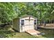 Backyard shed with double doors and window, perfect for outdoor storage at 1123 Poplar Forest Ln, Pittsboro, NC 27312
