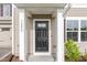 Close-up of a black front door with white trim, flanked by columns and house number 1204 at 1204 Bridgewater Dr, Durham, NC 27704