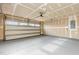 Spacious unfinished garage featuring painted floor and an automatic door opener at 1204 Bridgewater Dr, Durham, NC 27704