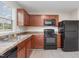 Kitchen area featuring wood cabinetry, appliances, and a stainless steel sink and faucet at 1204 Bridgewater Dr, Durham, NC 27704