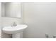 A simple powder room with a pedestal sink and mirror offers essential convenience at 1204 Bridgewater Dr, Durham, NC 27704