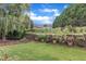 Home backyard showing tiered levels, a wrought iron fence, and lovely flowers and plants at 12227 Orchardgrass Ln, Raleigh, NC 27614