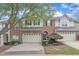 Charming townhome featuring a brick facade, attached garage, and well-manicured landscaping at 12227 Orchardgrass Ln, Raleigh, NC 27614