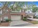 View of a lovely townhome with brick and siding, featuring an attached garage and attractive landscaping at 12227 Orchardgrass Ln, Raleigh, NC 27614