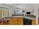 Well-lit kitchen with wood cabinets, a breakfast bar, and views into the adjacent dining area at 12227 Orchardgrass Ln, Raleigh, NC 27614